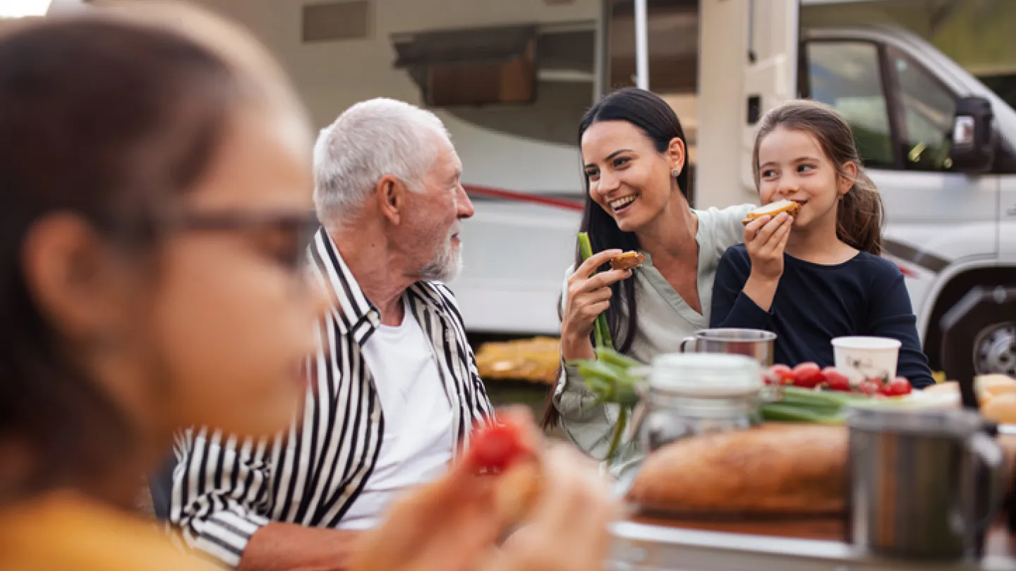 Familie koser seg utenfor bobilen